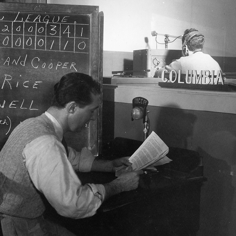 person looking at papers in front of chalkboard