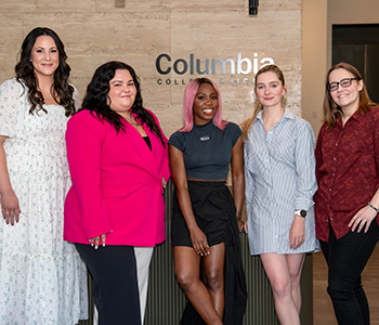 a group of alumni standing in front of Columbia building