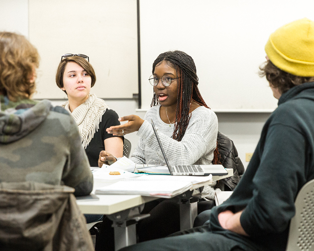 a group of combined degree student gather around a table