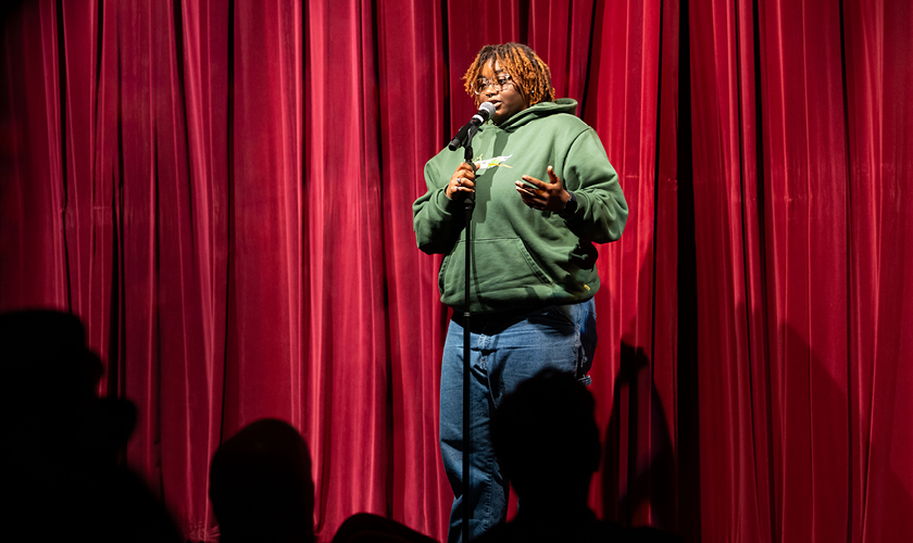 A comedy writing and performance degree student performs on stage