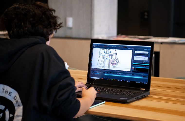 3D computer animation student draws on his laptop to complete the program