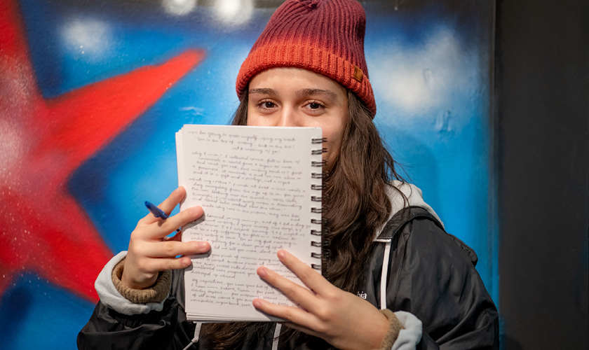 English major student reads from a notebook