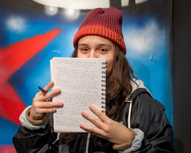 English major student reads from a notebook