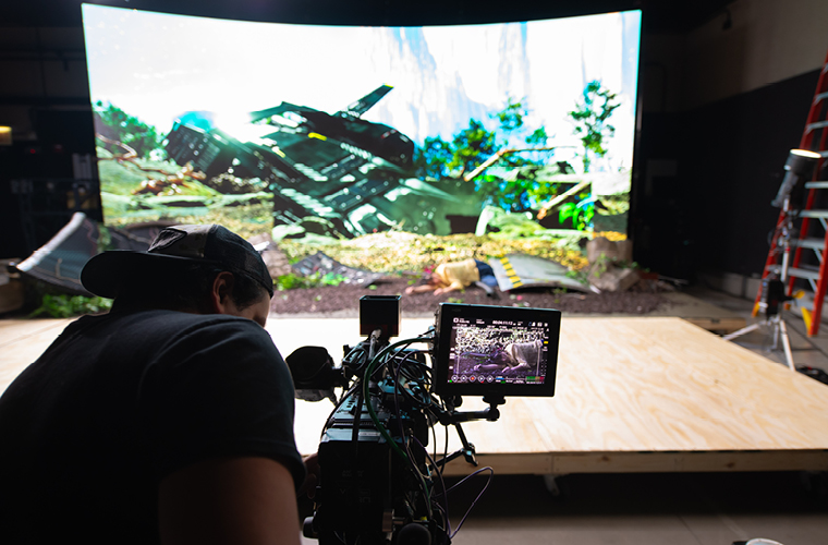 a film student works on a camera on a virtual production set