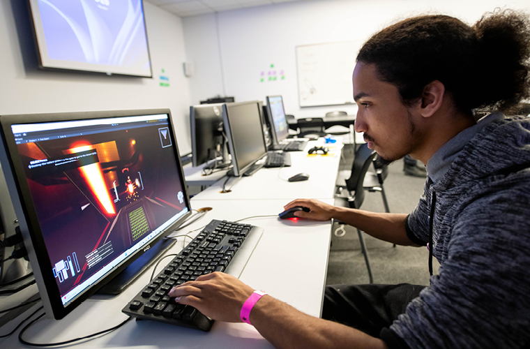 a game design major plays a game in a computer lab