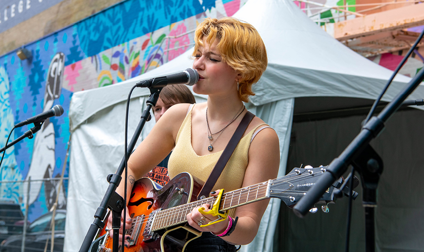 Musician on stage singing and playing guitar