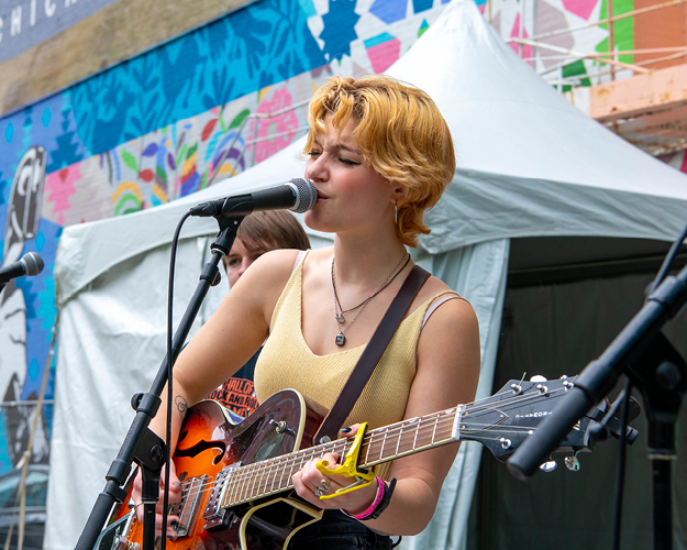 Musician on stage singing and playing guitar