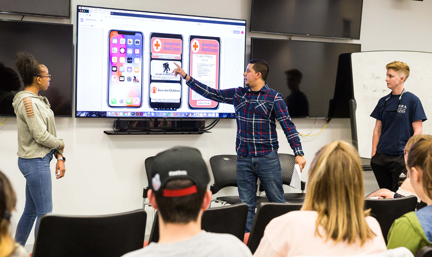 two social media students present in front of a class for a social media course