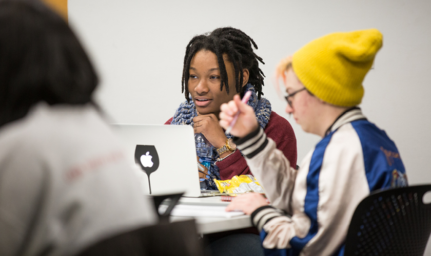 a strategic communications masters degree student sits in class and listens thoughtfully