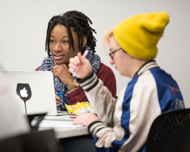 a strategic communications masters degree student sits in class and listens thoughtfully