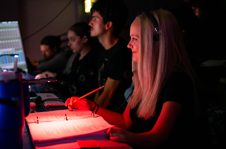 a theatre directing student works behind the scenes 