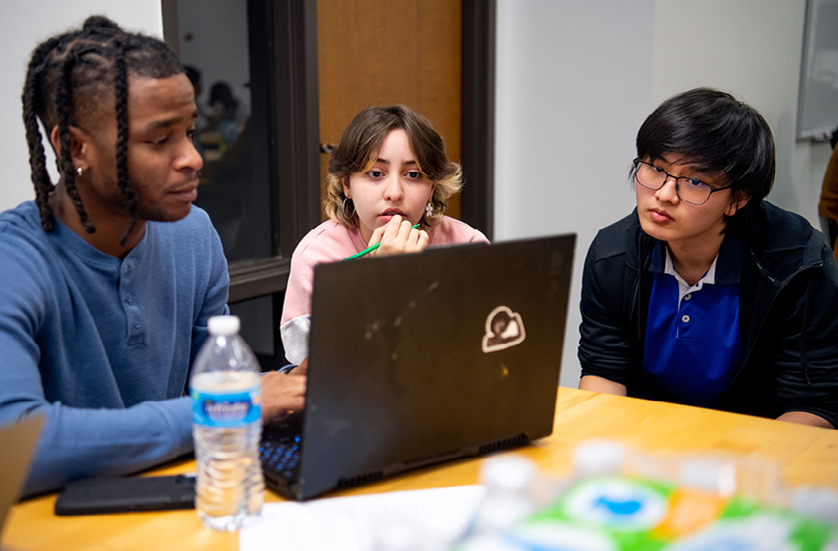 a group sitting at tables with computers