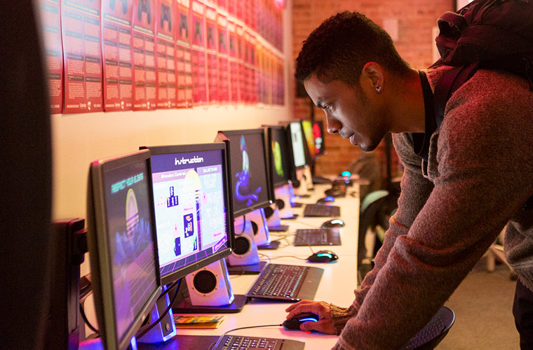 person standing and looking at computer screen