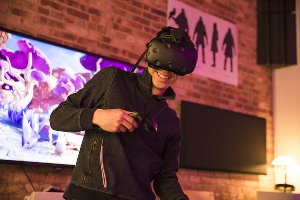 person with virtual reality gear standing in front of screen