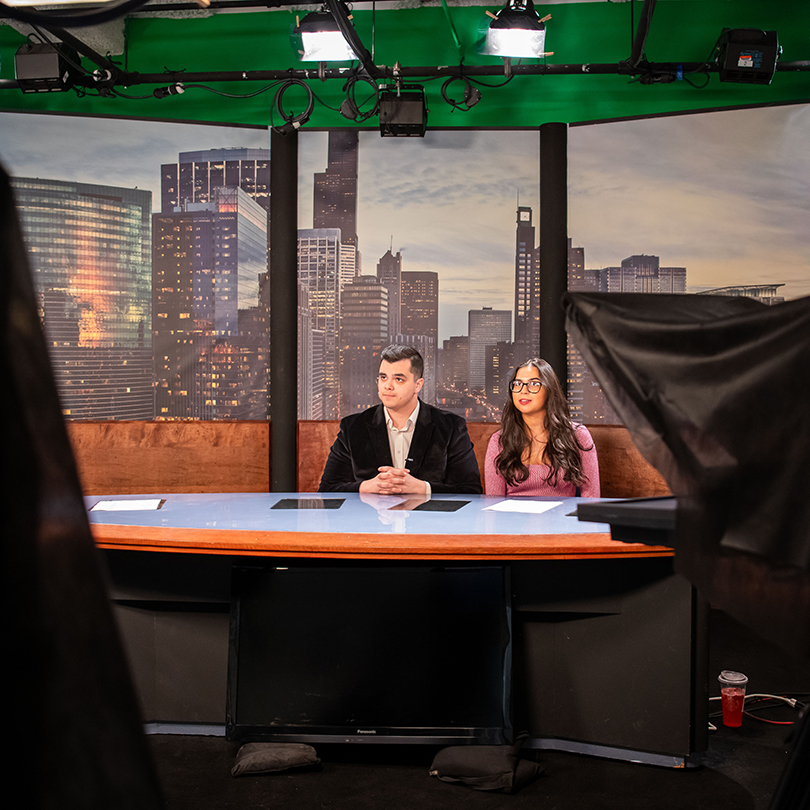 students sitting at news desk