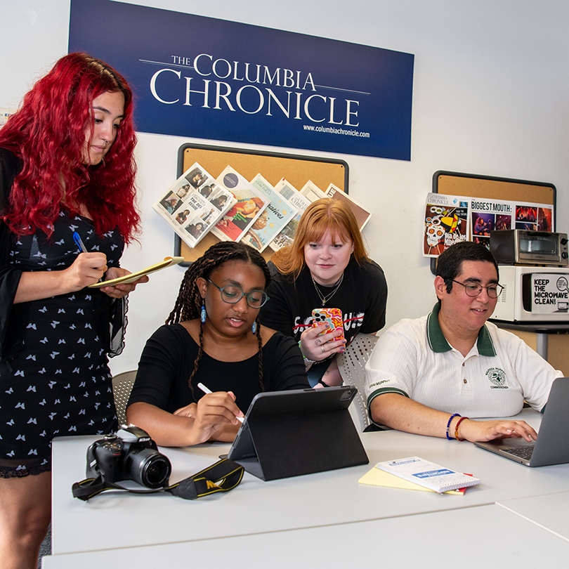 students working at desk in columbia chronicle newspaper office