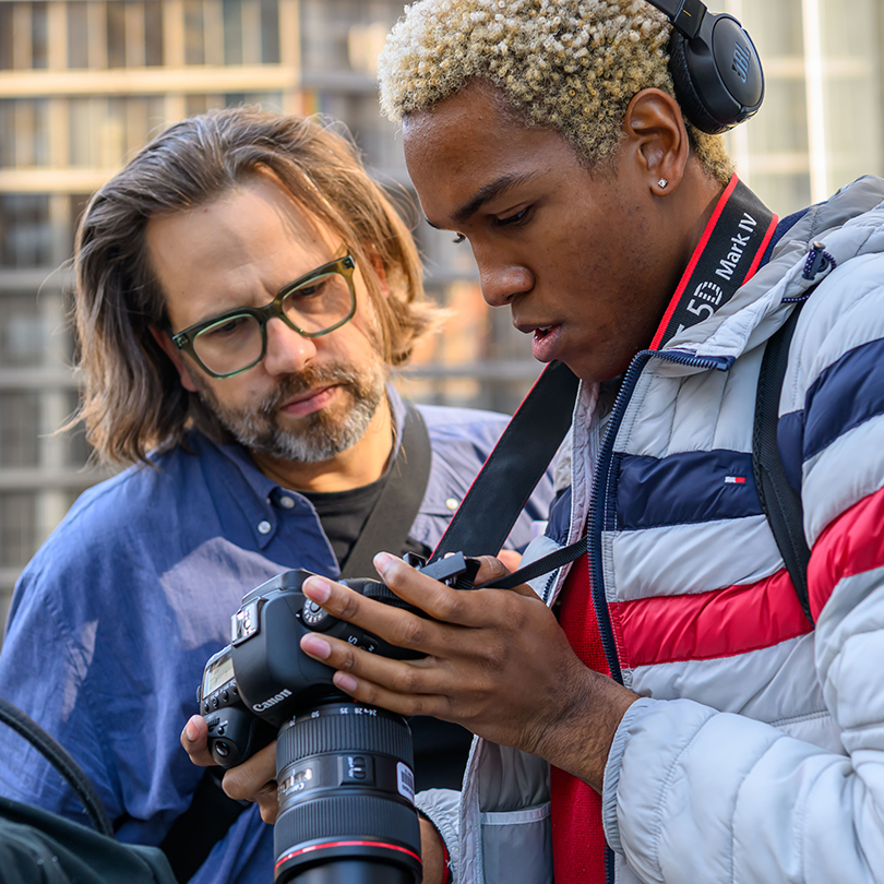 faculty member and student reviewing photos on digital camera