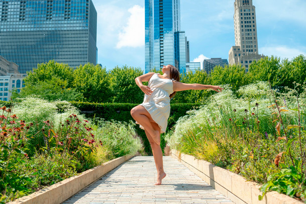 A dance student poses on toe at Maggie Daley Park surrounded by wildlife. 