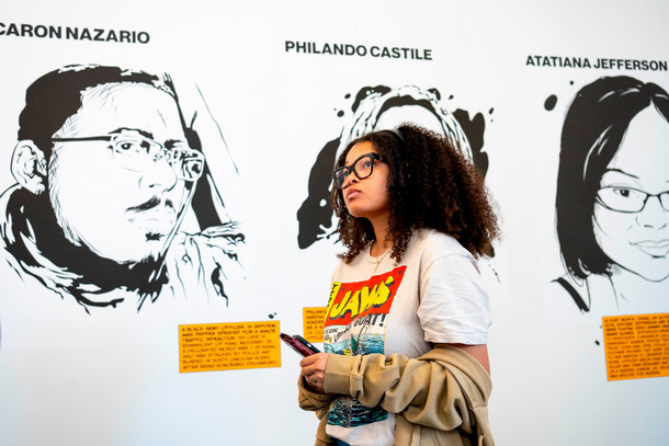 A student looks up at ink tributes of victims of police violence made by alum Marlon West.