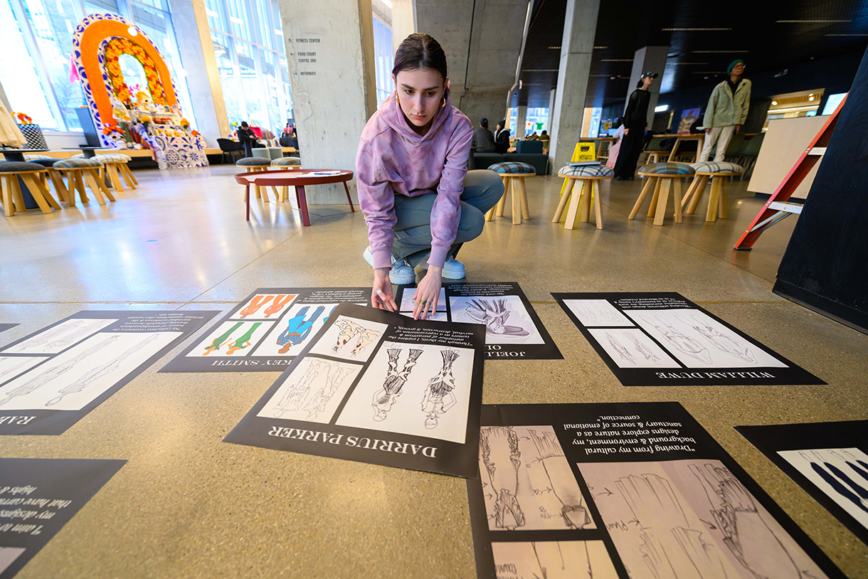 person kneeling over signage on floor