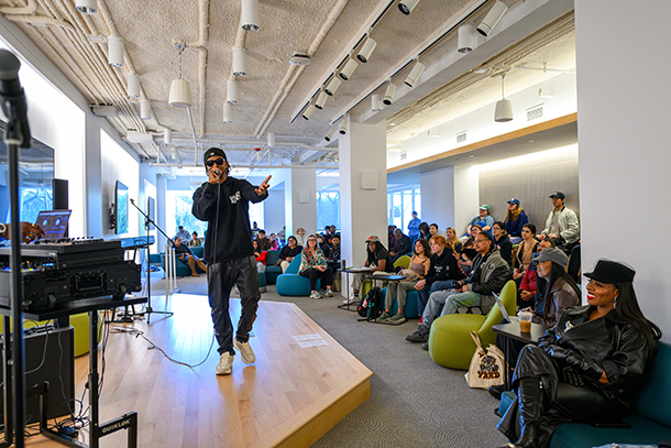 person on stage with microphone with audience listening