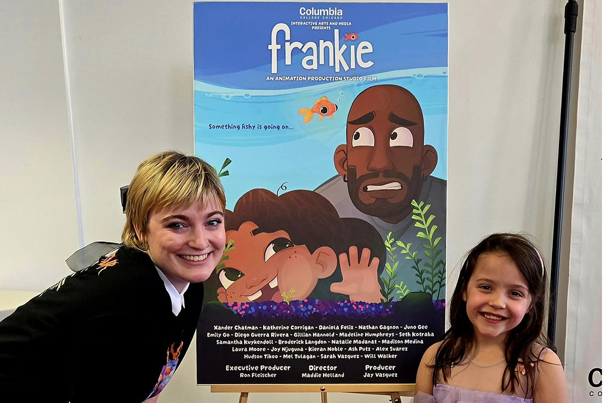 an adult and child pose in front of frankie poster
