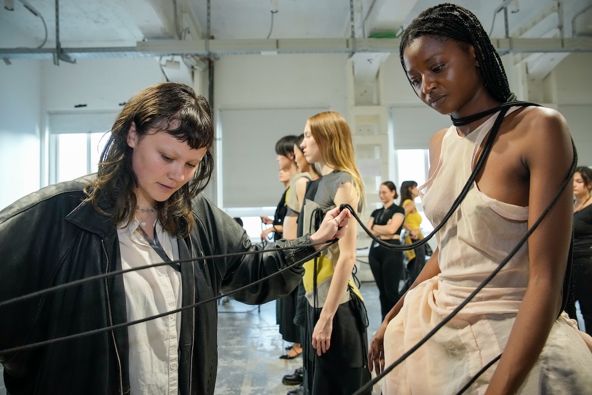 Student designer Rae Breazeale adjusts a rope accessory for one of their designs on a model during fittings for the City to City fashion show in Milan, Italy. Photo by Gianluca Carraro