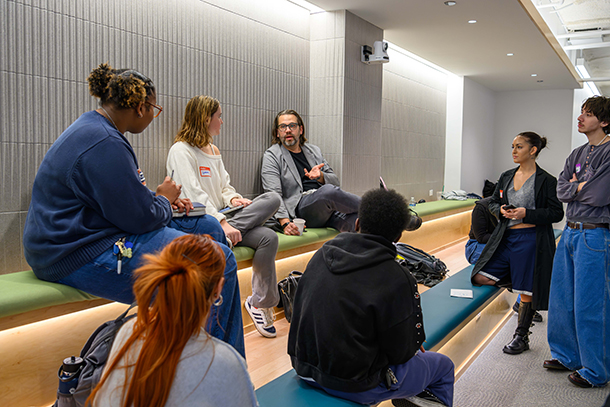 group of students in lounge talking to adult