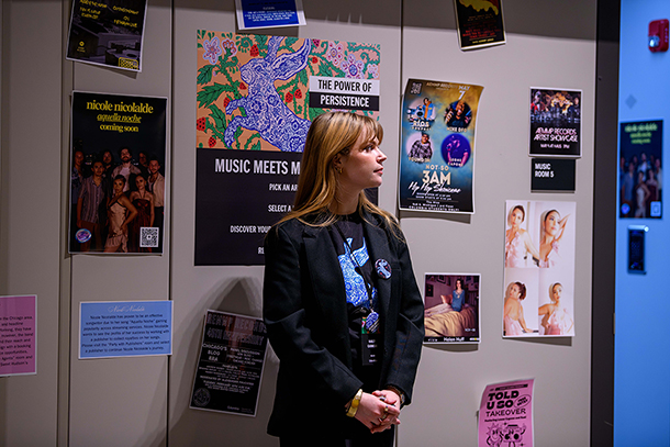 person standing in front of concert and promotional videos