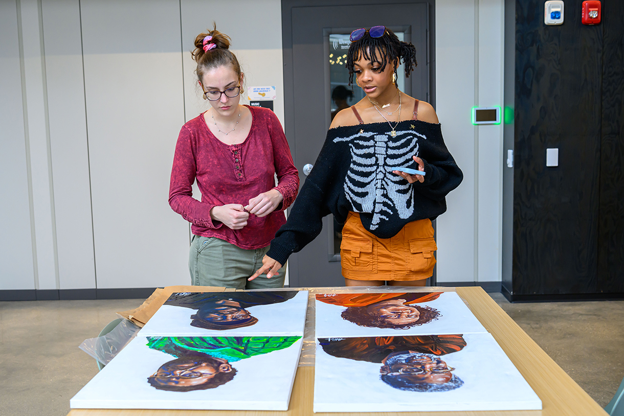 students overlook artwork on table